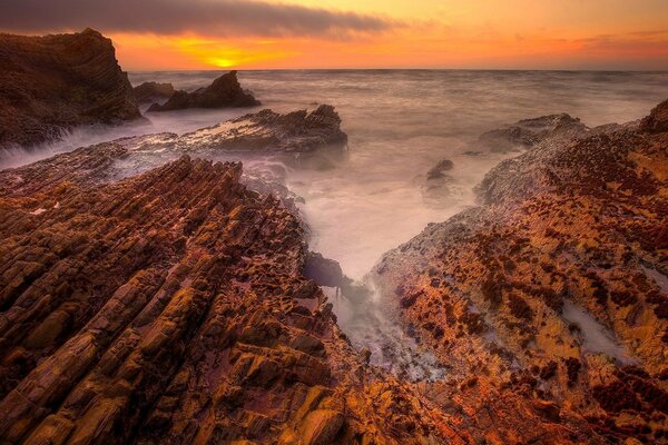 Hermosa puesta de sol y costa rocosa