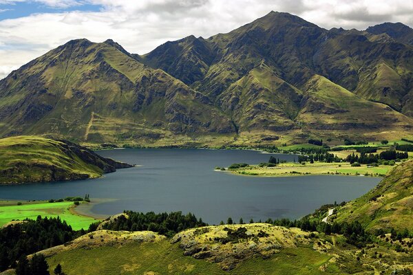 Lake landscape among green mountain peaks and hills