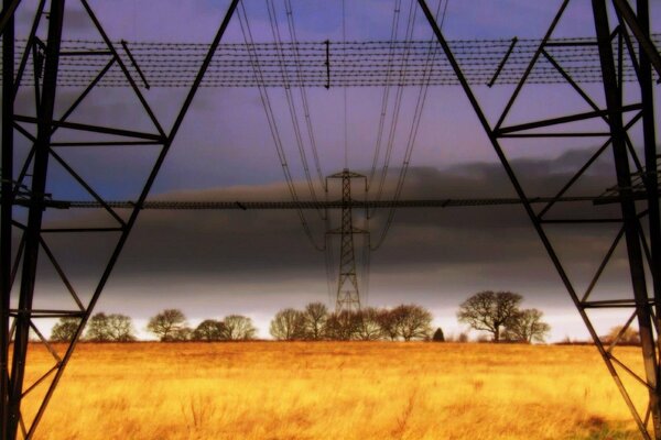 Power lines in the field. Towers under voltage