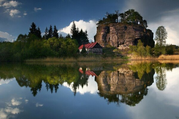 Casa solitaria bajo una roca en el lago