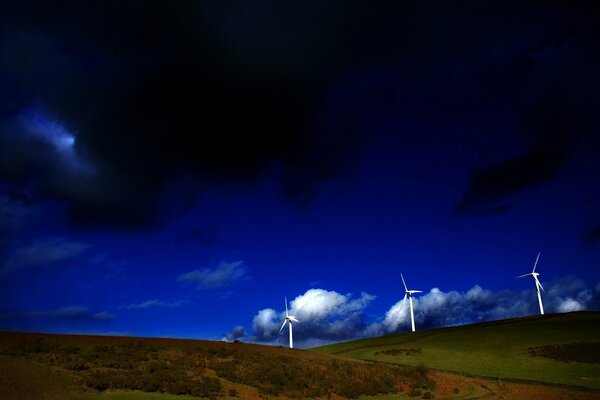 Three windmills behind high hills