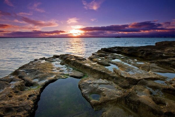 Vista del tramonto dalla spiaggia rocciosa