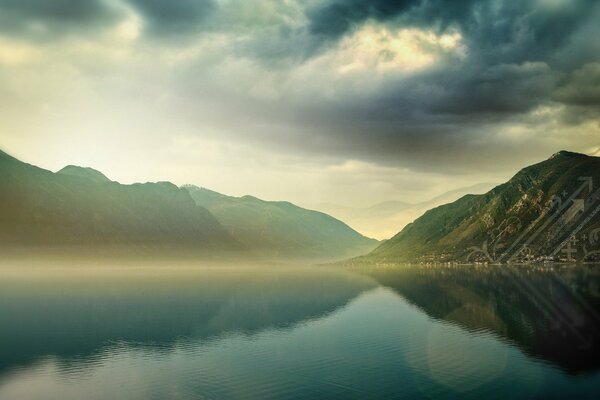 Mirror water of a mountain lake under clouds