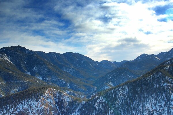 Altas montañas cubiertas de nieve entre las nubes