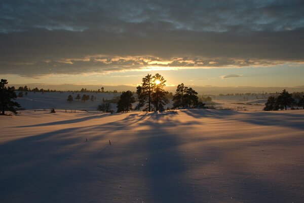 Puesta de sol, extensiones de nieve de invierno