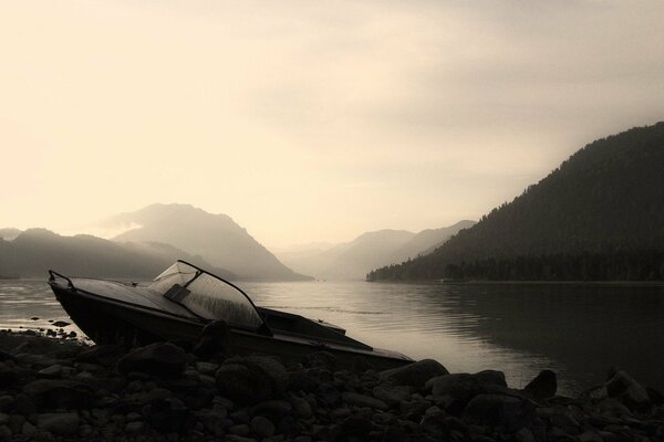 Jezioro a Góry. Czarno-biała łódź na skałach
