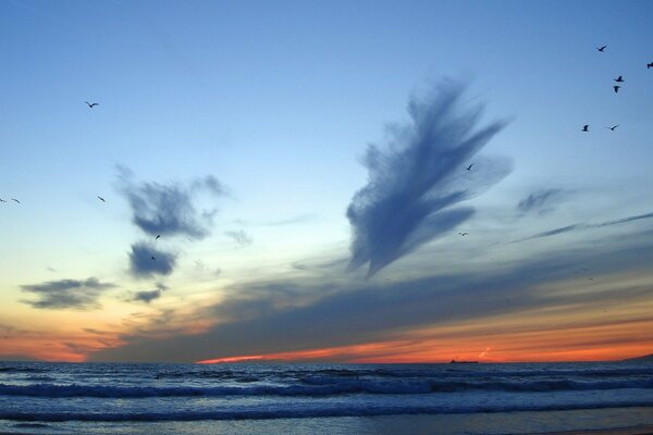 Das Meer geht mit Wellen über den Horizont hinaus und kollidiert mit Wolken am Himmel