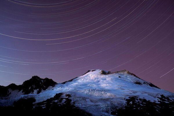 Danza delle stelle sopra la cima innevata