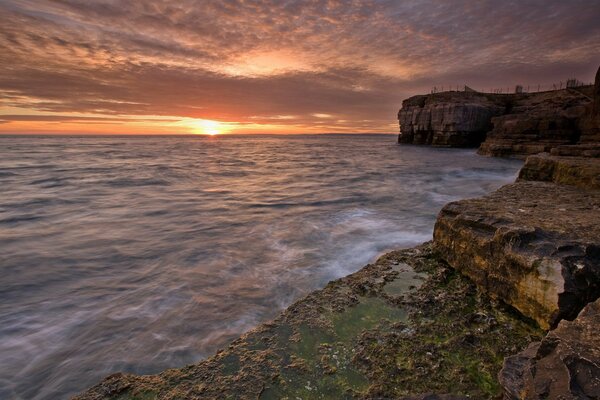 Stone shore by the water at sunset