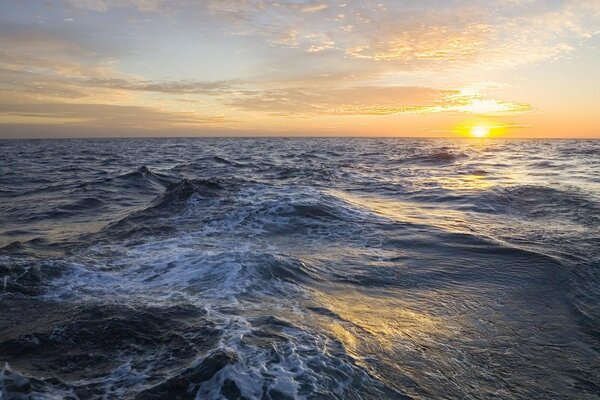 Mar azul agitado antes de la puesta del sol
