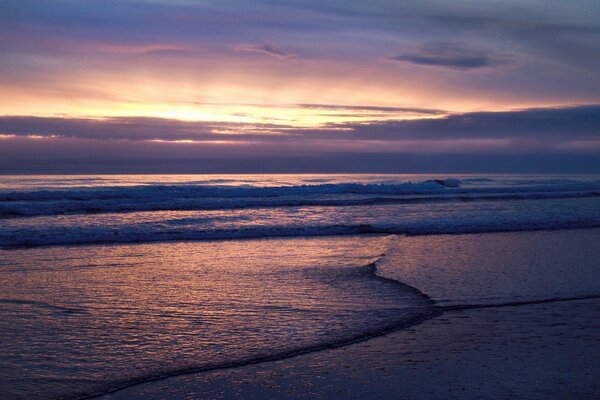 Vagues de la mer sur fond de coucher de soleil et de nuages