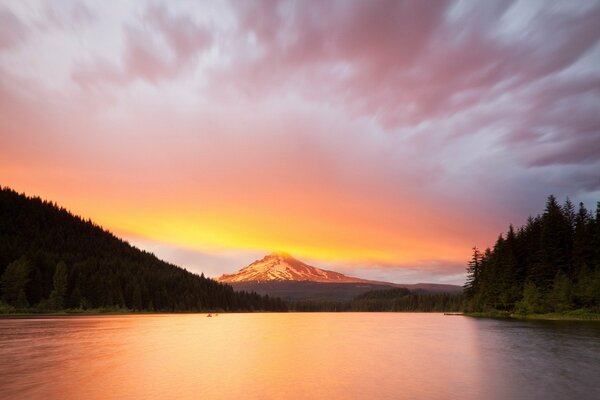 Lago al tramonto e montagne tra le nuvole