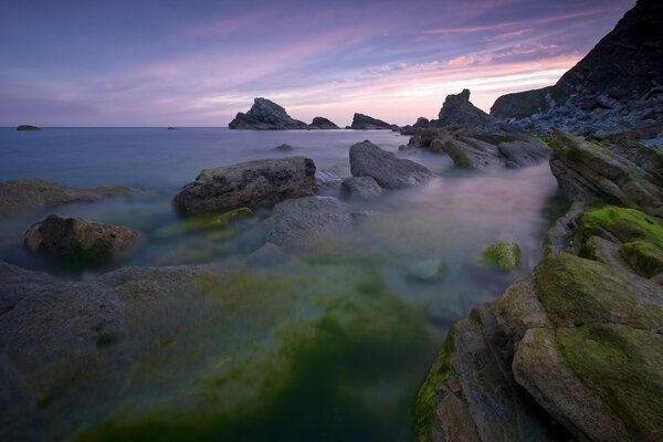 Costa rocosa contra el cielo al atardecer