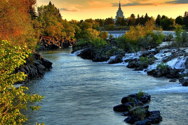 Autumn landscape of the river with rocky shores, rapids and sunset sky