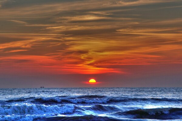 Wellen im Meer und Sonnenuntergang in purpurroten Farben