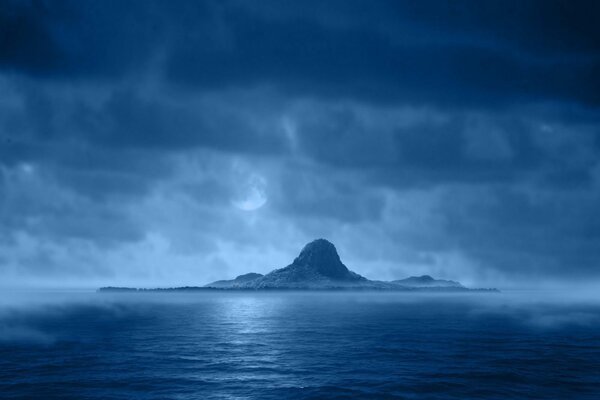 Montagne bleue sur la mer dans les nuages