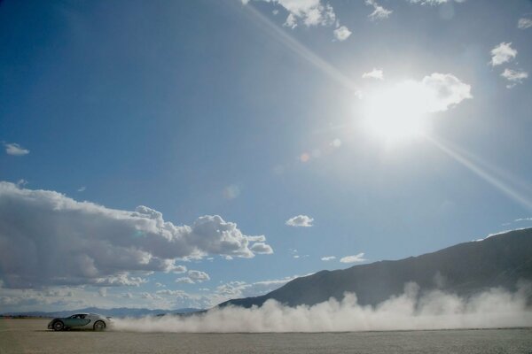 Bugatti corre attraverso il deserto sollevando polvere