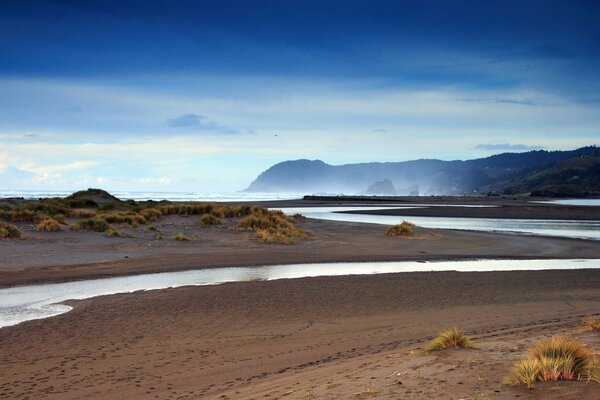 La desembocadura del río entre la orilla arenosa