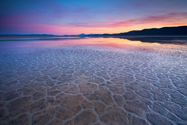 Reflection of the sunset in the water surface, on the site of the desert