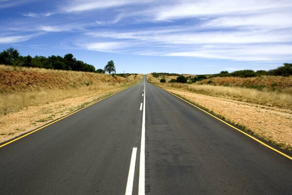 Eine Straße mit einer Oasenmarkierung, die zum Horizont führt