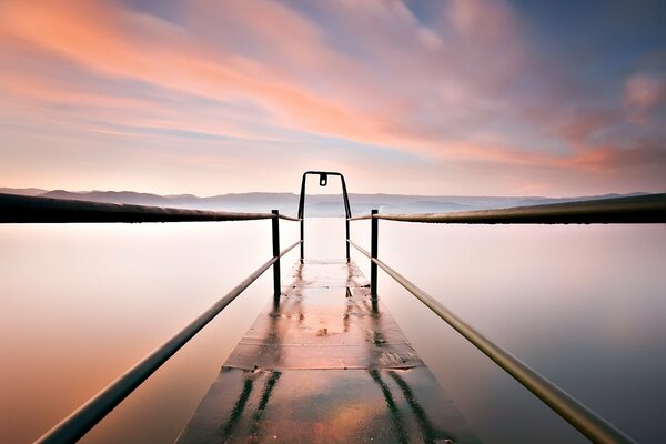 Embarcadero en el lago en medio de nubes Rosadas