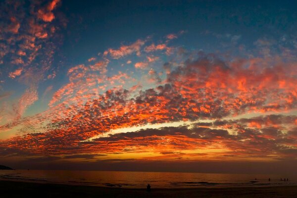 Over the sea, the clouds of wondrous beauty turned scarlet in the sunset rays