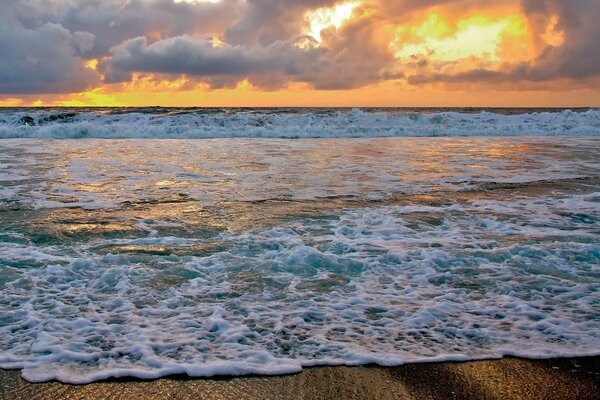 Vagues dans le surf au coucher du soleil d or