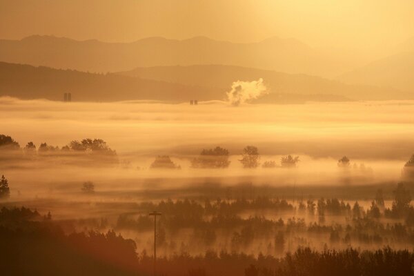 Dans le brouillard du matin, on voit un village endormi