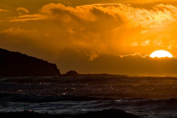 The sun is hiding behind the horizon of the exciting sea