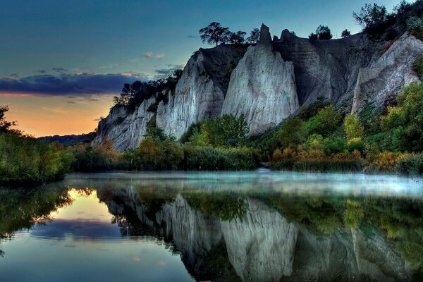 Gray rocks are reflected in the surface of the lake