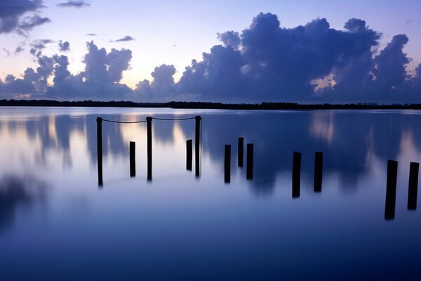 Holzmasten am Abend im Fluss