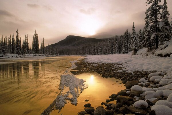 The river is a rocky shore with a snow-covered cover