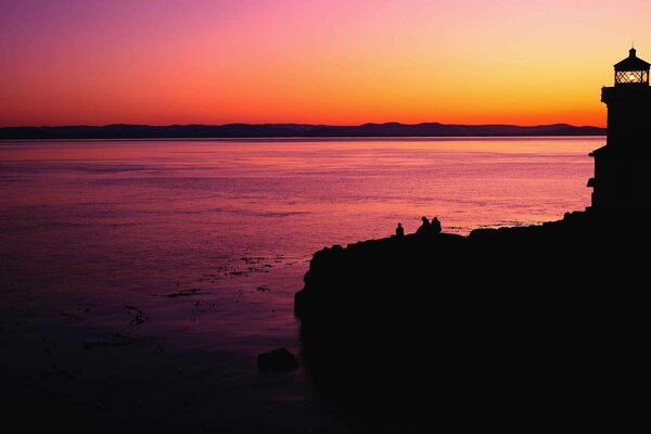 Leuchtturm und Meer in den Farben des Sonnenuntergangs