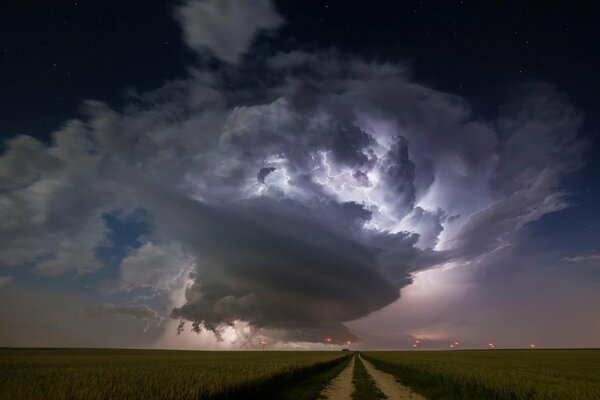 On a narrow road in a field, lightning rang out in the sky