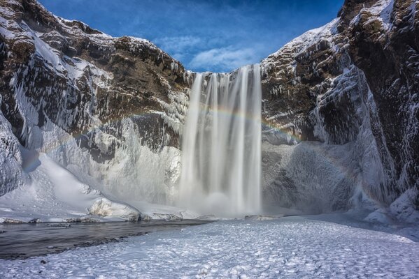 Wasserfall zwischen Schnee und Bergen in Island