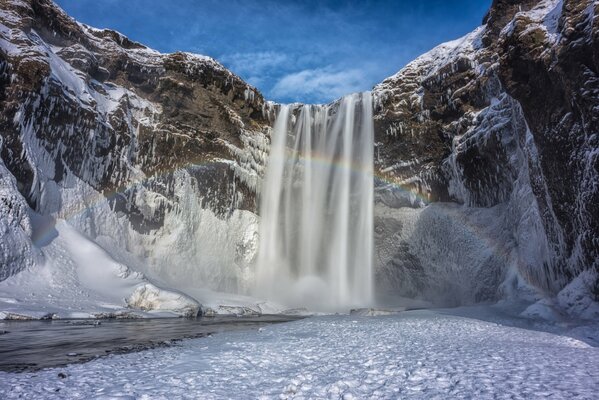 Waterfall among snow and mountains in Iceland