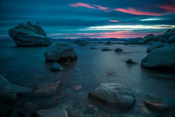 Stones on the water horizon at dawn