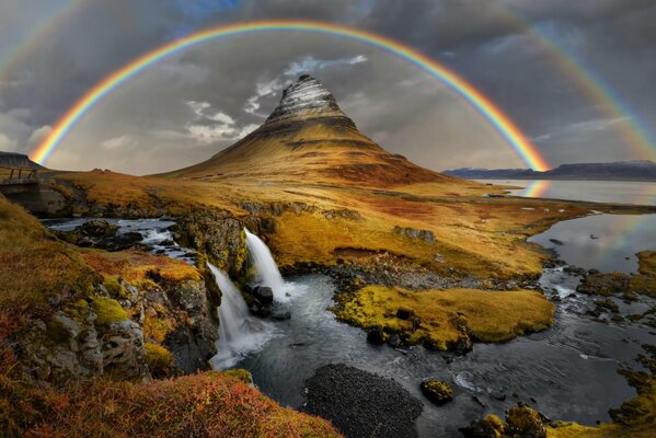 Der Regenbogen über dem Berg betont die Schönheit der Natur