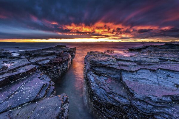 Attraverso le rocce si vede il mare al tramonto