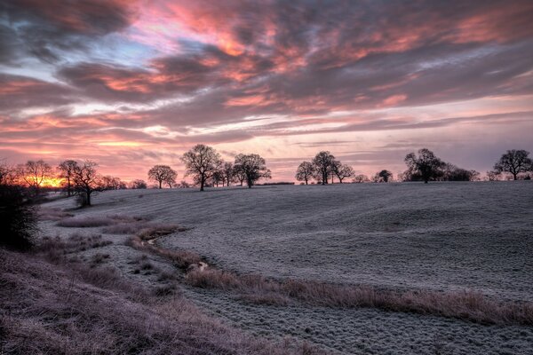 Sunset fills the frozen field with a crimson hue