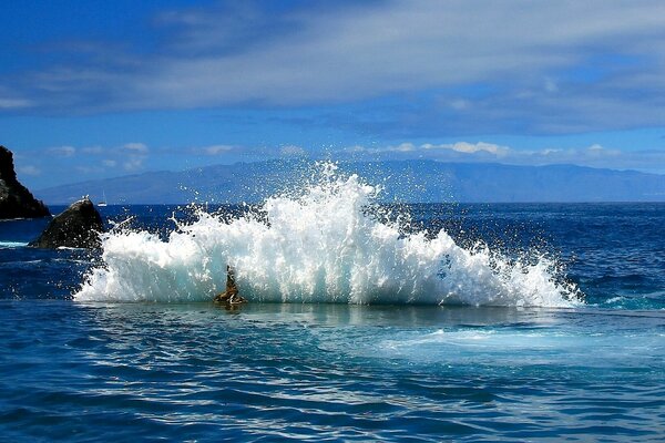 The sea waves are beating against the rocks