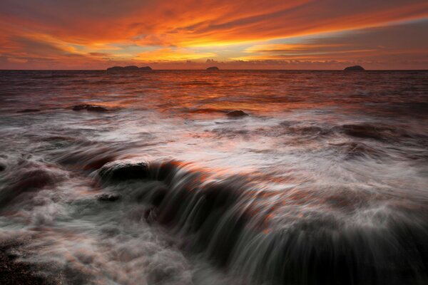 Sunset on the horizon from the stone cliffs by the sea