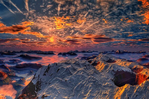 Montañas cubiertas de nieve en el fondo de la puesta de sol