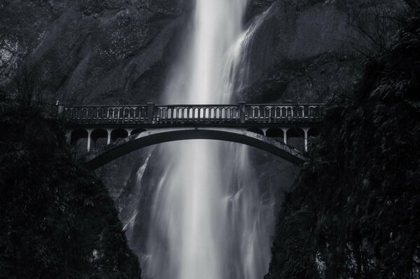 Schwarz-Weiß-Foto mit Brücke und Wasserfall