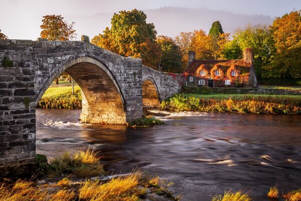 Steinbrücke über dem Fluss im Herbst