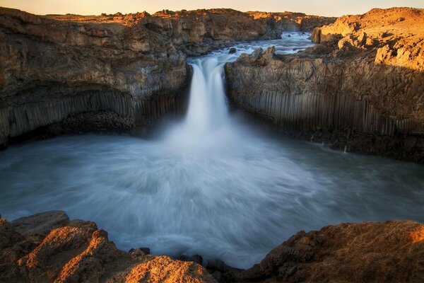 A huge waterfall going into the lake