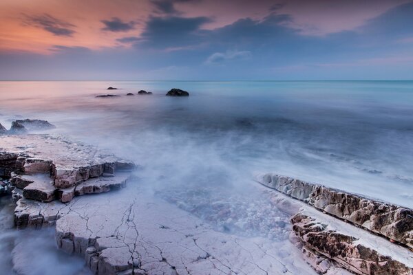 The clouds merge with the abyss of fog and the sea smoothly turns into the sky