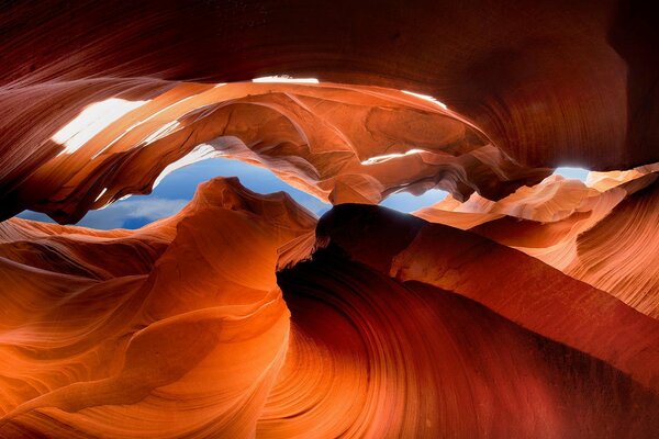 Orange Felsen in einer hellen Höhle unter blauem Himmel