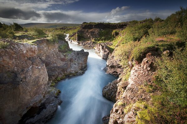 Fiume tra rocce e nuvole