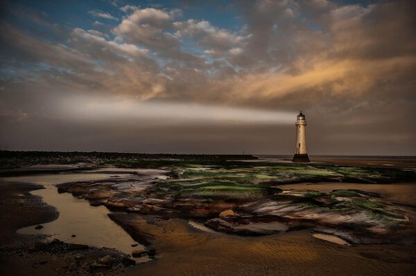 The bright beam of the lighthouse in the evening